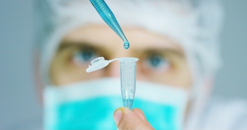 a scientist in a laboratory, analyzing the plants and earth tubes and slides in and take up the dna and does research in biochemistry. concept: analysis, dna, bio, microbiology, love of nature