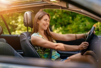 young beautiful smiling girl driving a car. 
