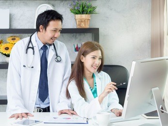 two doctors discussing about patient with computer in clinic healthcare and medical concept.