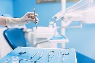 detail of hand holding dental tools in dental clinic. dentist concept.