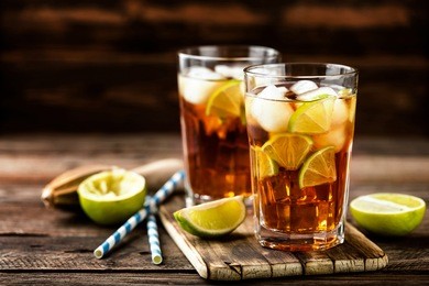 cuba libre or long island iced tea cocktail with strong drinks, cola, lime and ice in glass, cold longdrink or lemonade