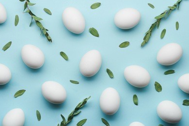 white eggs with green leaves on mint color table