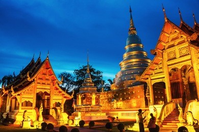 chiang mai, thailand. illuminated temples of phra singh in chiang mai, thailand at sunset. golden walls and blue sky