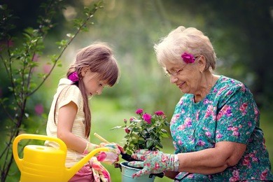happy grandmother with her granddaughter working in the garden.