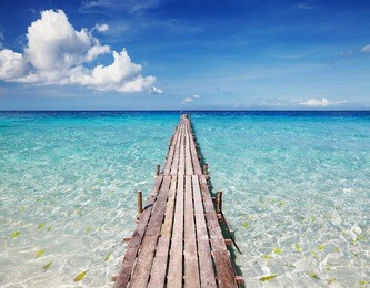 wooden pier on a tropical island, clear sea and blue sky
