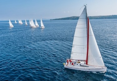 racing sail boat from bird view, many of sailing boats in background