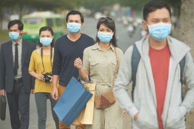 citizens walking on the street in masks because of danger of epidemic