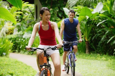 couple cycling through a park