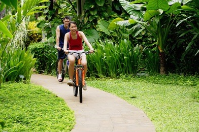 couple cycling leisurely through a park