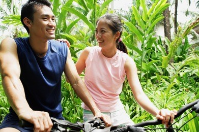 couple on bikes, woman with hand on mans shoulder