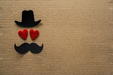 happy father's day background or card. black sign of hat, mustache and pipe with two red heart - eyes. empty copy space for inscription. 
