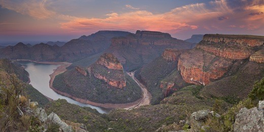 view over the blyde river canyon and the three rondavels in south africa at sunset.
