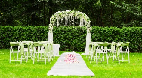 wedding arch and chairs on the green grass in the park.wedding ceremony decoration