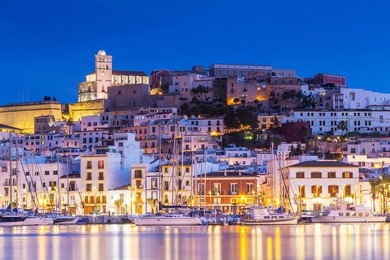 ibiza dalt vila downtown at night with light reflections in the water, ibiza, spain.