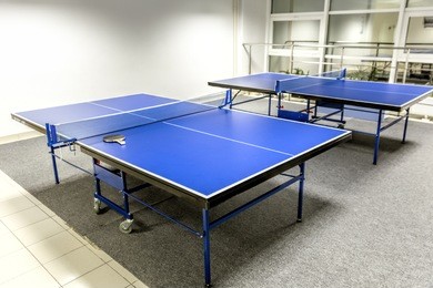 two blue ping pong tables in the room