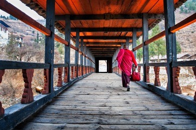 monk walking towards rinpung monastery, paro, bhutan