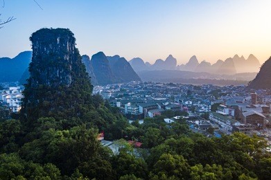 yangshuo sunset cityscape skyline with karst mountains in guangxi province, china