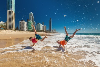 two young happy boys doing hand stands on gold coast beach, australia