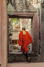 buddhist monk among the ruins of preah khan temple in angkor, cambodia.