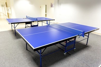 two blue ping pong tables in the room