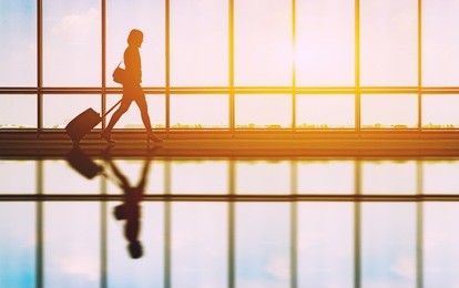 travel concept, people in the airports ,silhouette of young girl with luggage walking at airport, women showing something through the window,selective focus,vintage tone color