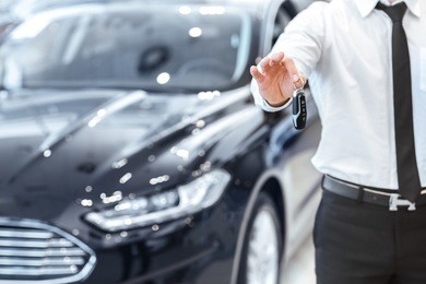 passing car keys. cropped closeup of a car dealer holding out car keys to the camera copyspace car dealership salon manager salesman selling buying giving owner profession purchase vehicle concept  