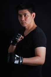 asian fighter boxer standing strong on black background