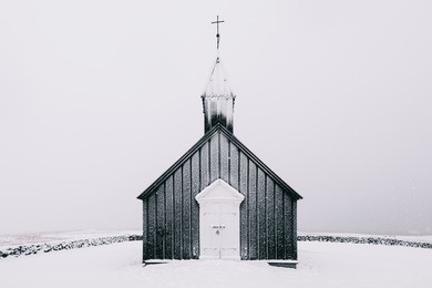 beautiful minimalistic view of budir black church in the snaefellsnes peninsula during severe snowstorm