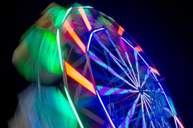 abstract motion blur ferris wheel spinning at night, long exposure.