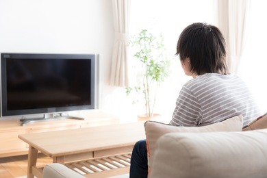 young asian man watching tv in  the living room