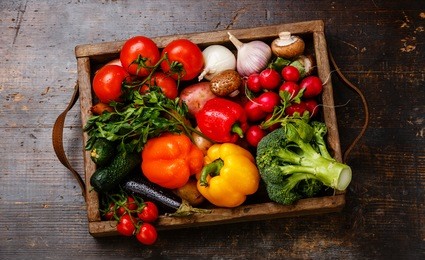 fresh vegetables in wooden box on wooden background