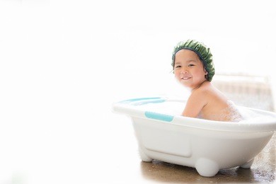 asian little girl playing with water and foam on white background.