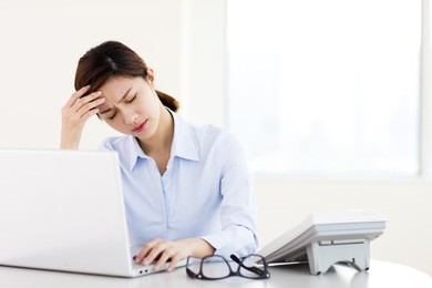 young businesswoman with tired eyes and headache