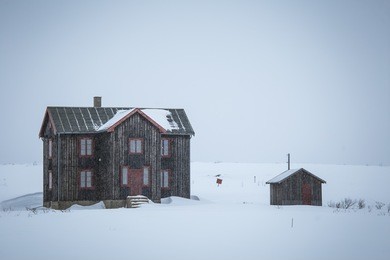 a beautiful, minimalistic landscape of a house in the snow in norway