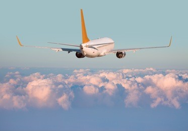passenger jet plane flies above the clouds