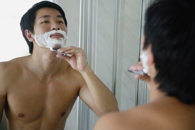 man looking in mirror, shaving