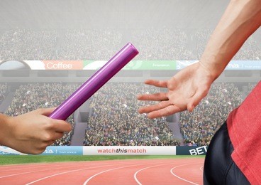 digital composition of athlete passing baton during relay race against stadium i background