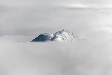 view of snow-covered mountains of a valley of the zillertal in foggy weather - mayrhofen, austria  