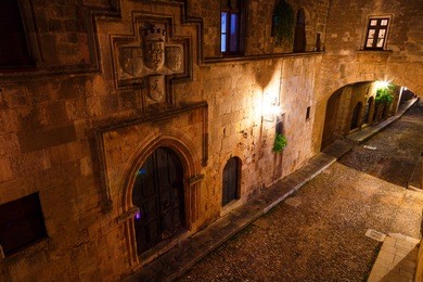 medieval avenue of knights at night, a cobblestone street in rhodes citadel , greece