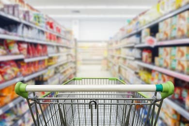 supermarket aisle with empty green shopping cart