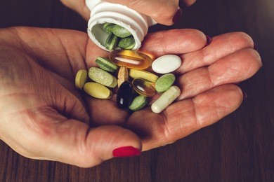 woman's hands poured the mix of vitamins and nutritional, dietary supplement pills from a bottle, close-up