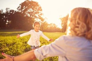 nice little girl run to mother's hug in nature 
