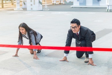 the businessman and businesswoman ready to run on start position with commitment to success