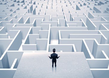 an elegant businessman standing on a square platform looking over infinite labyrinth concept