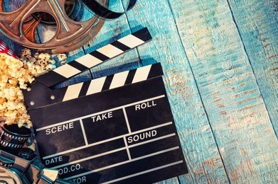 film camera chalkboard , movie camera, roll and popcorn on wooden planks. copyspace for text