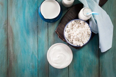 dairy products on wooden table over blue background