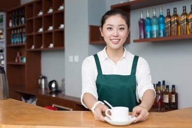 young beautiful woman works near counter in cafe