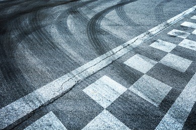 finish and start pattern line racing on the asphalt road background with crossing of tires tracks.