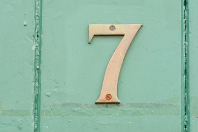 house number 7 sign on green painted door