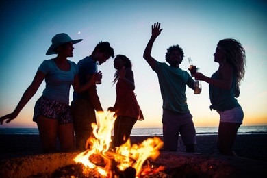 multicultural group of friends partying on the beach - young people celebrating during summer vacation, summertime and holidays concepts